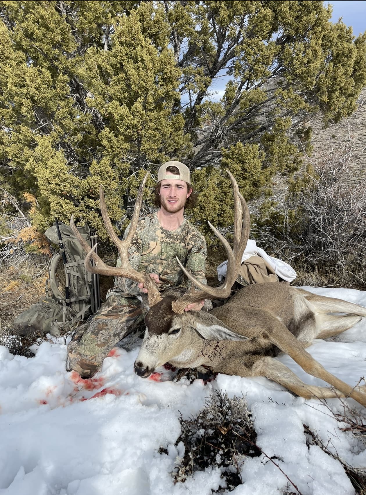 Derek Stevenson outdoors in Nevada with a harvested mule deer